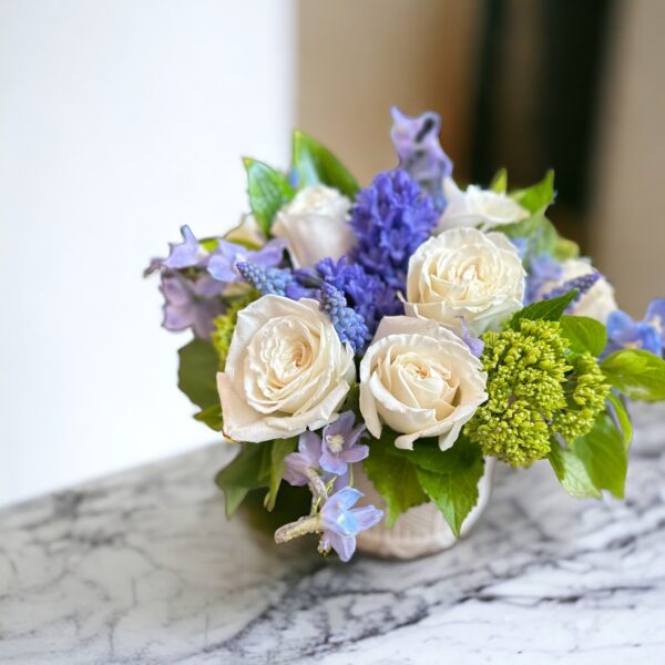 premium flowers - white, blue and green - in a low ceramic vase