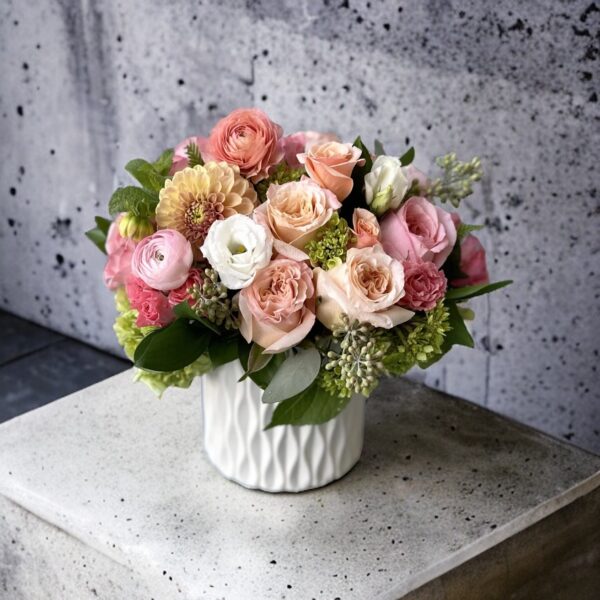 white ceramic vase with pink, orange, white and green flowers