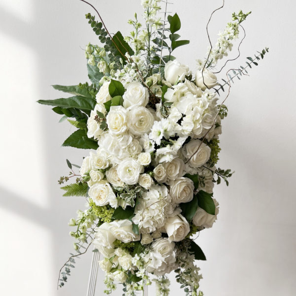 Floral spray of premium blooms on a white easel