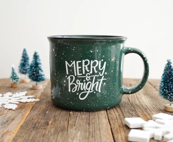 green ceramic mug with "merry & bright" lettering