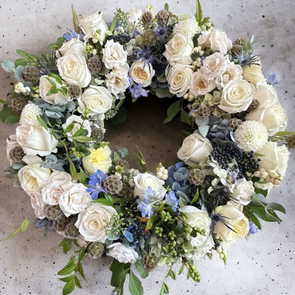 fresh floral wreath with white, blue and green flowers